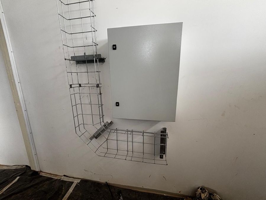 Eletrocalha aramada com curva chegando ao quadro elétrico